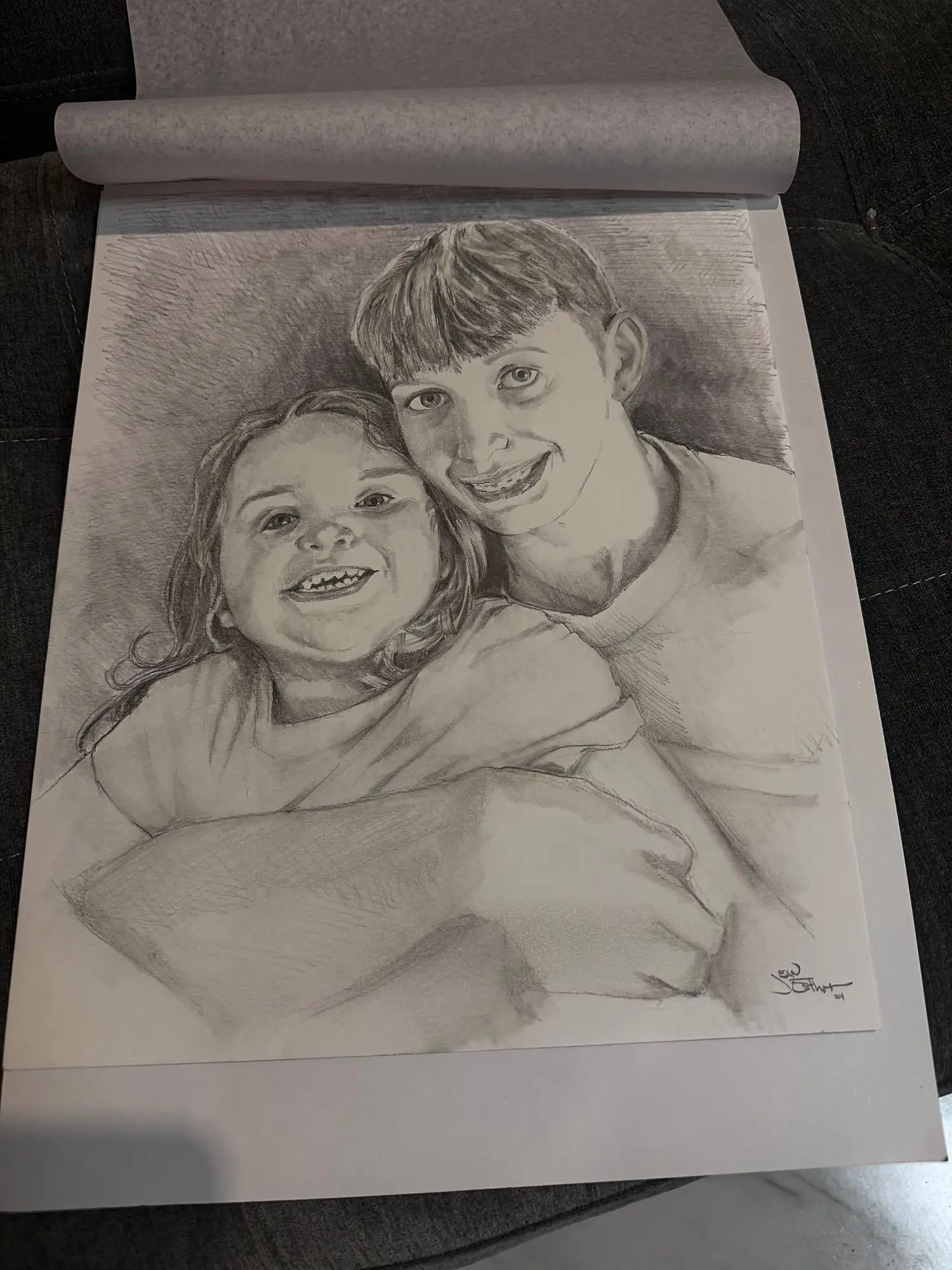 Pencil portrait of a brother and sister hugging