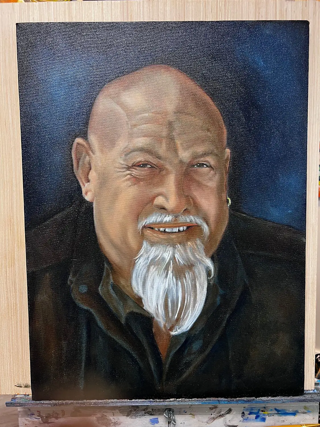 Oil portrait of a smiling man with a white goatee