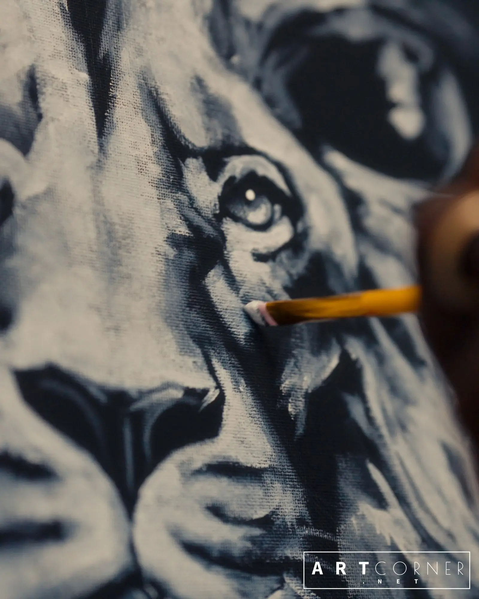 Close-up of Lion King, an acrylic painting by Jean Esther, with a brush adding highlights