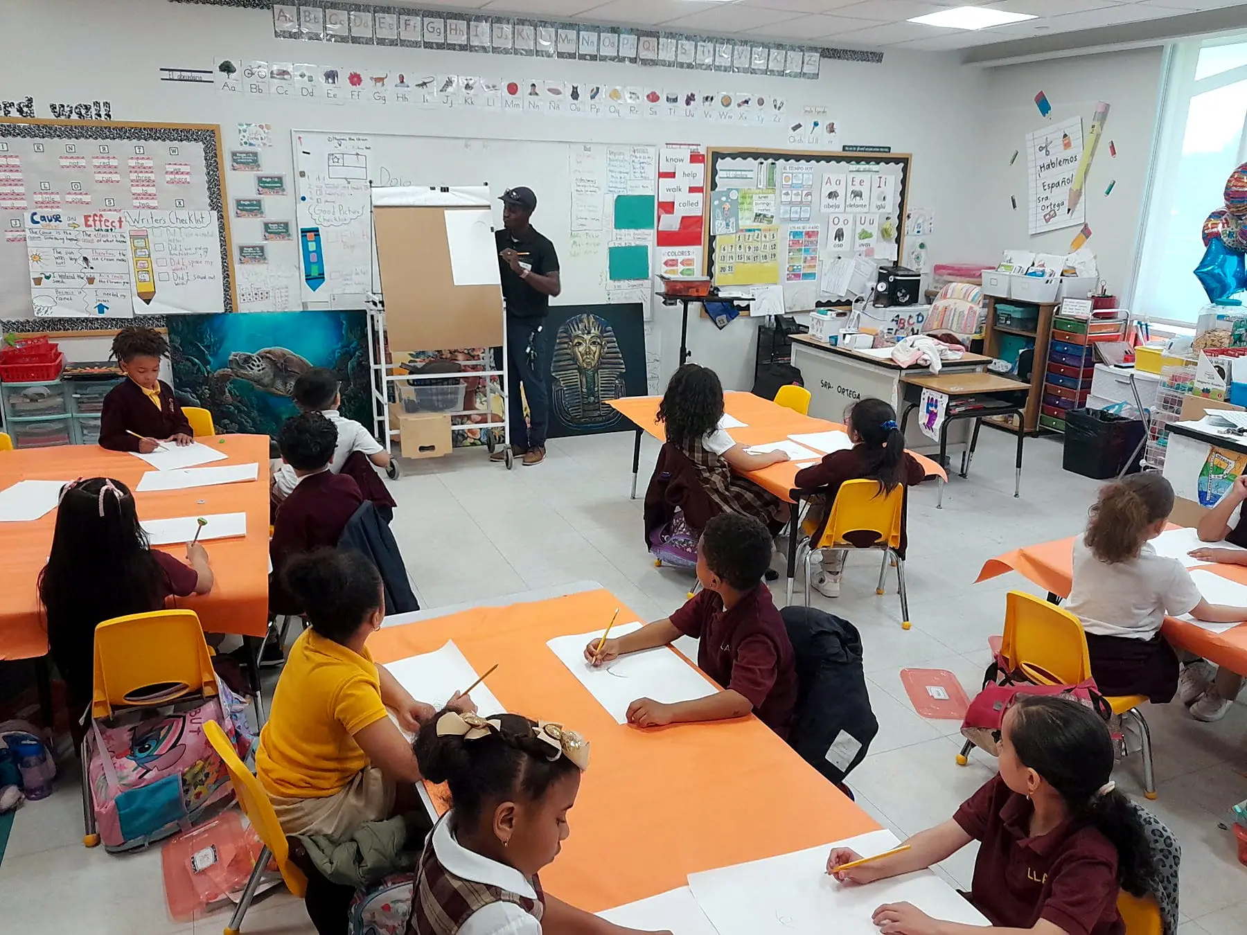 Students drawing at their desks during a school visit