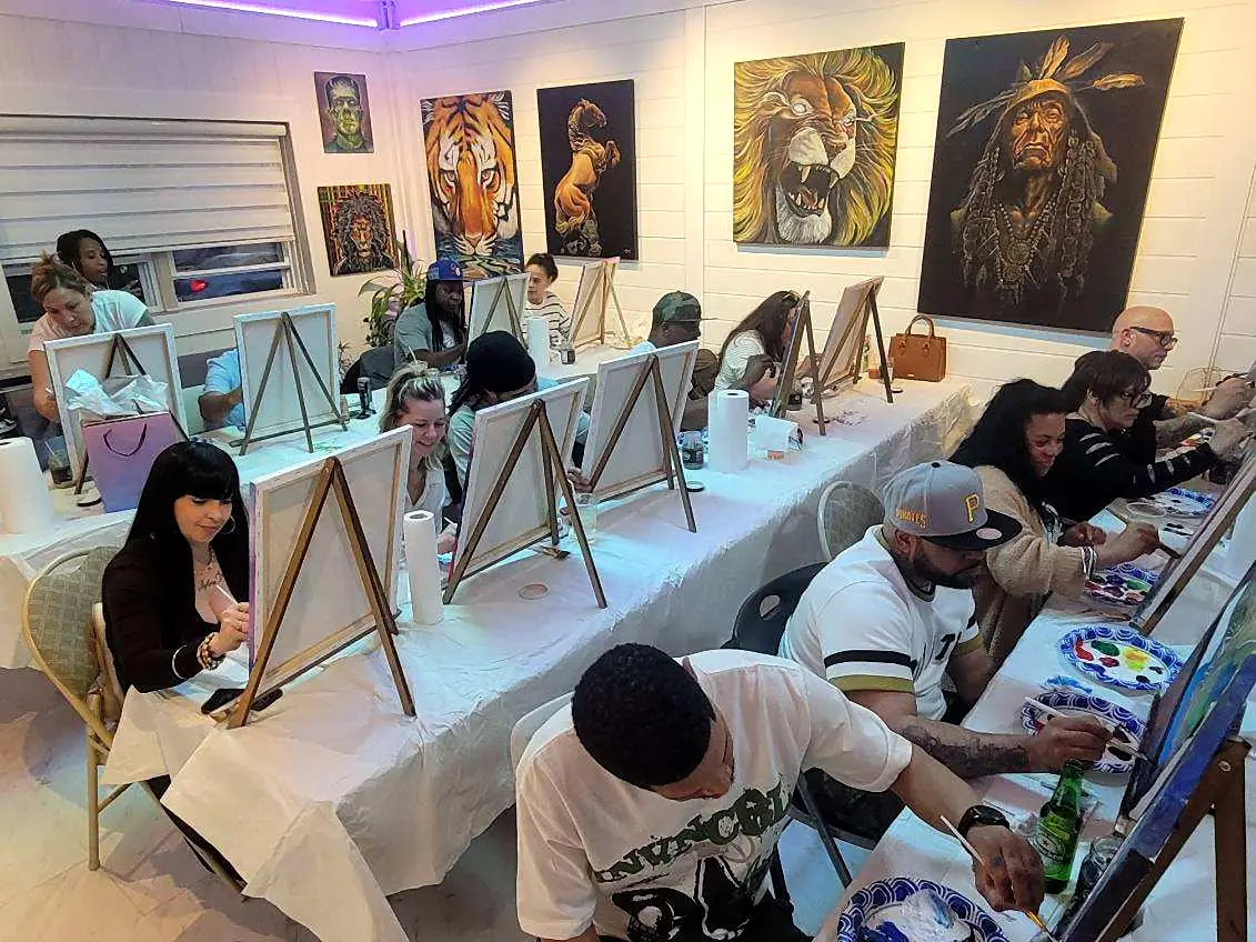 A full studio of painters under the gallery wall