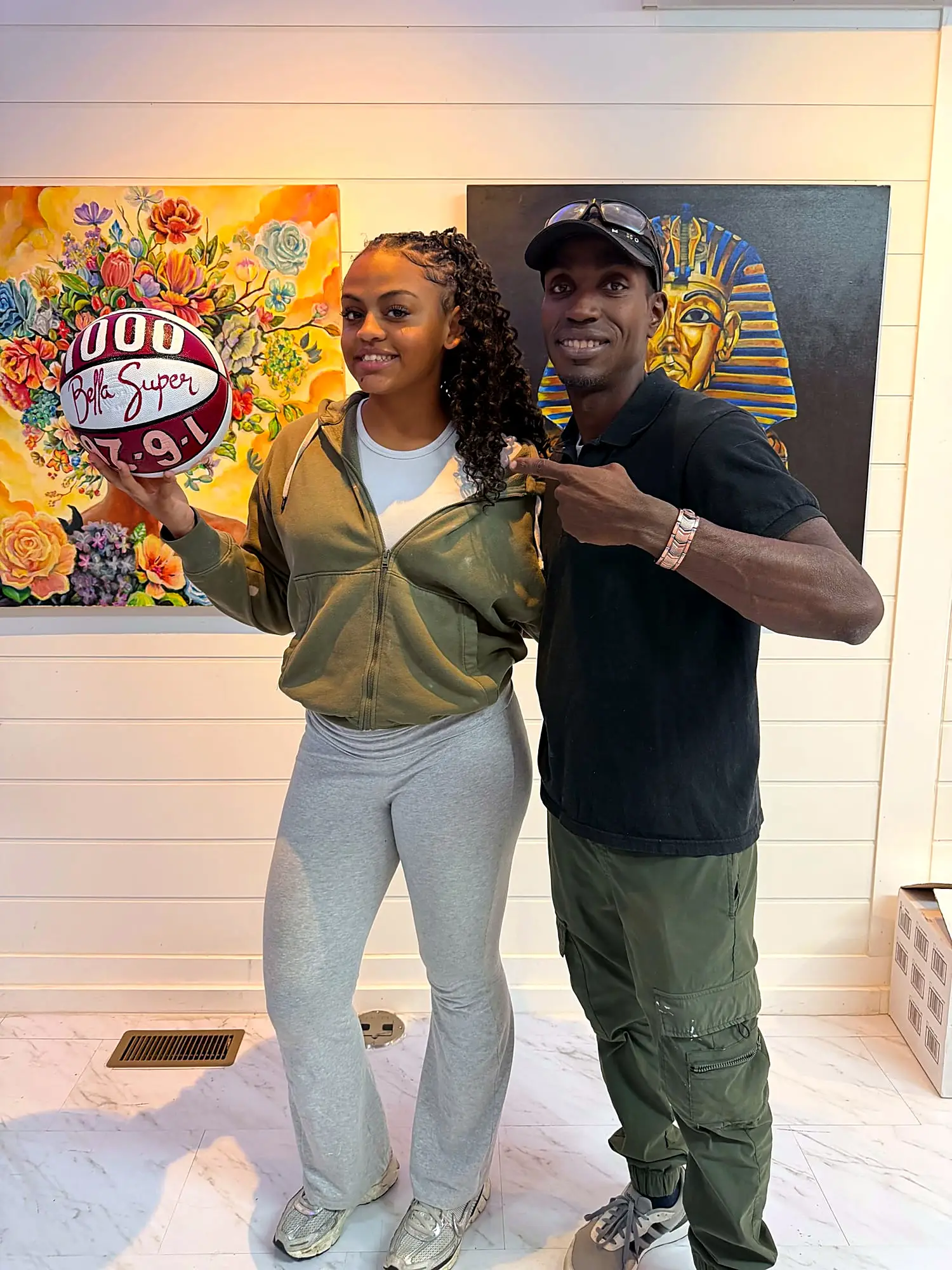Jean Esther with a guest in front of the studio paintings
