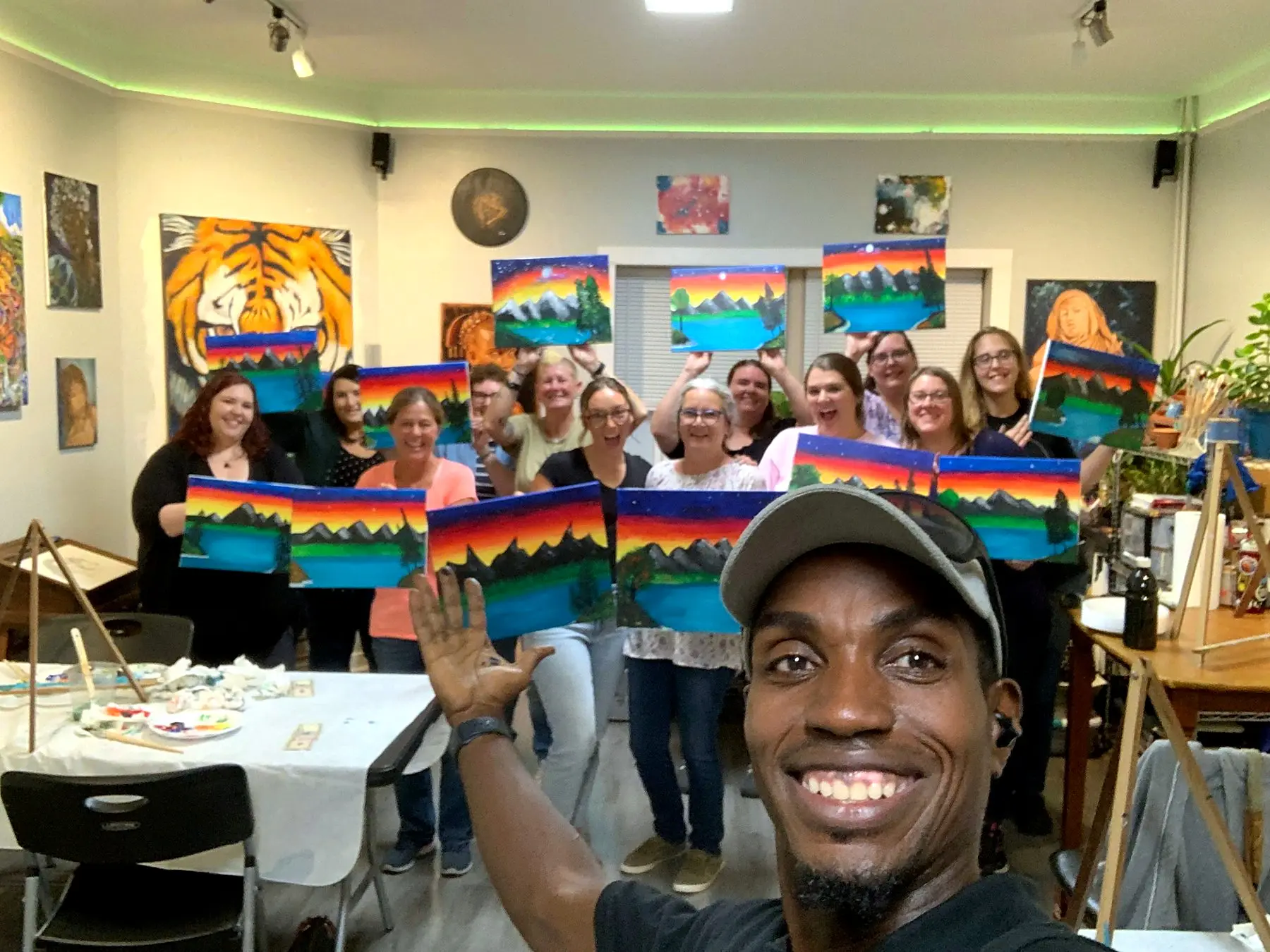 Jean Esther takes a selfie with a paint party and their sunset canvases