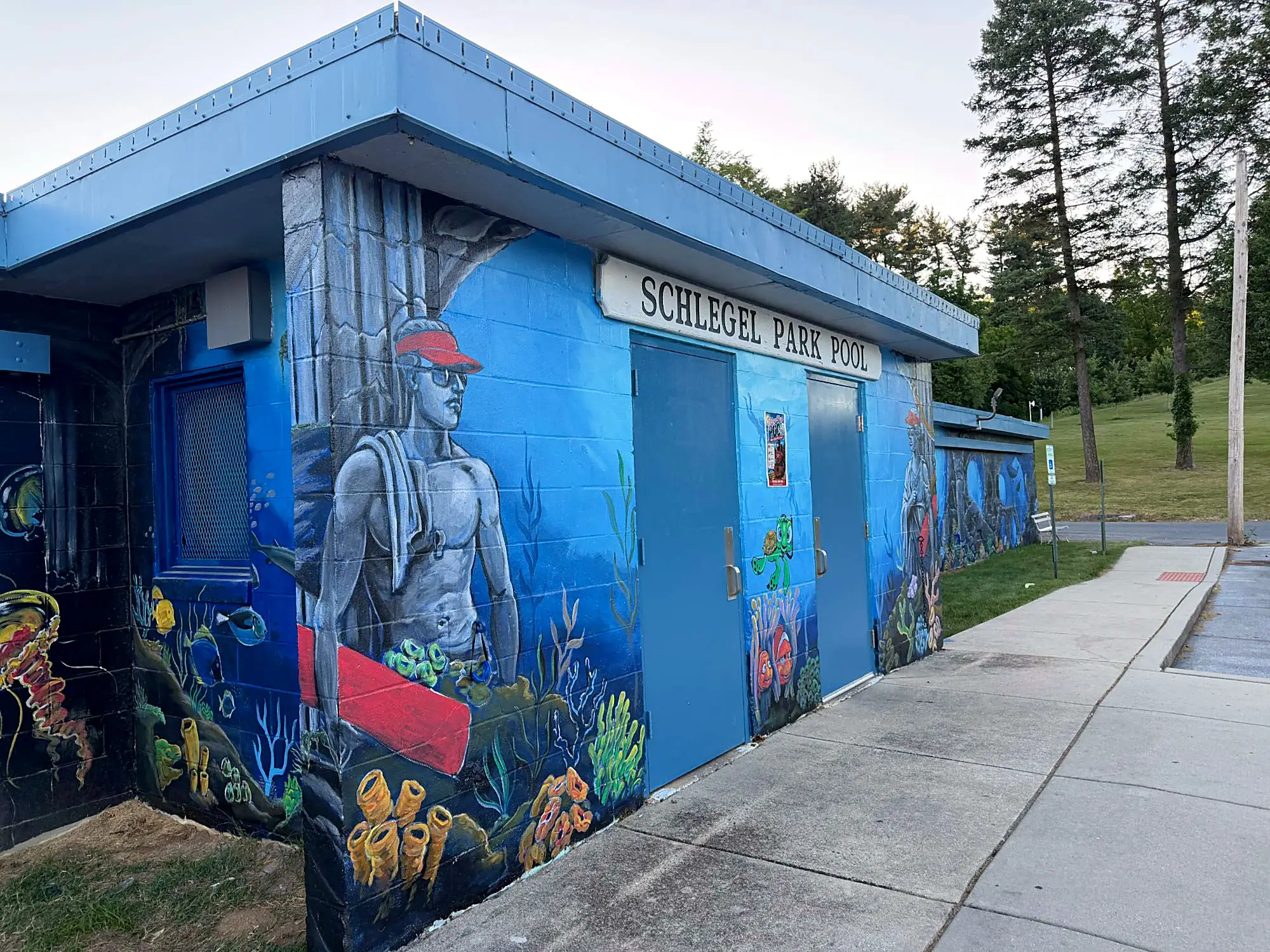 Underwater mural with a lifeguard, sea turtle and clownfish on the Schlegel Park Pool building