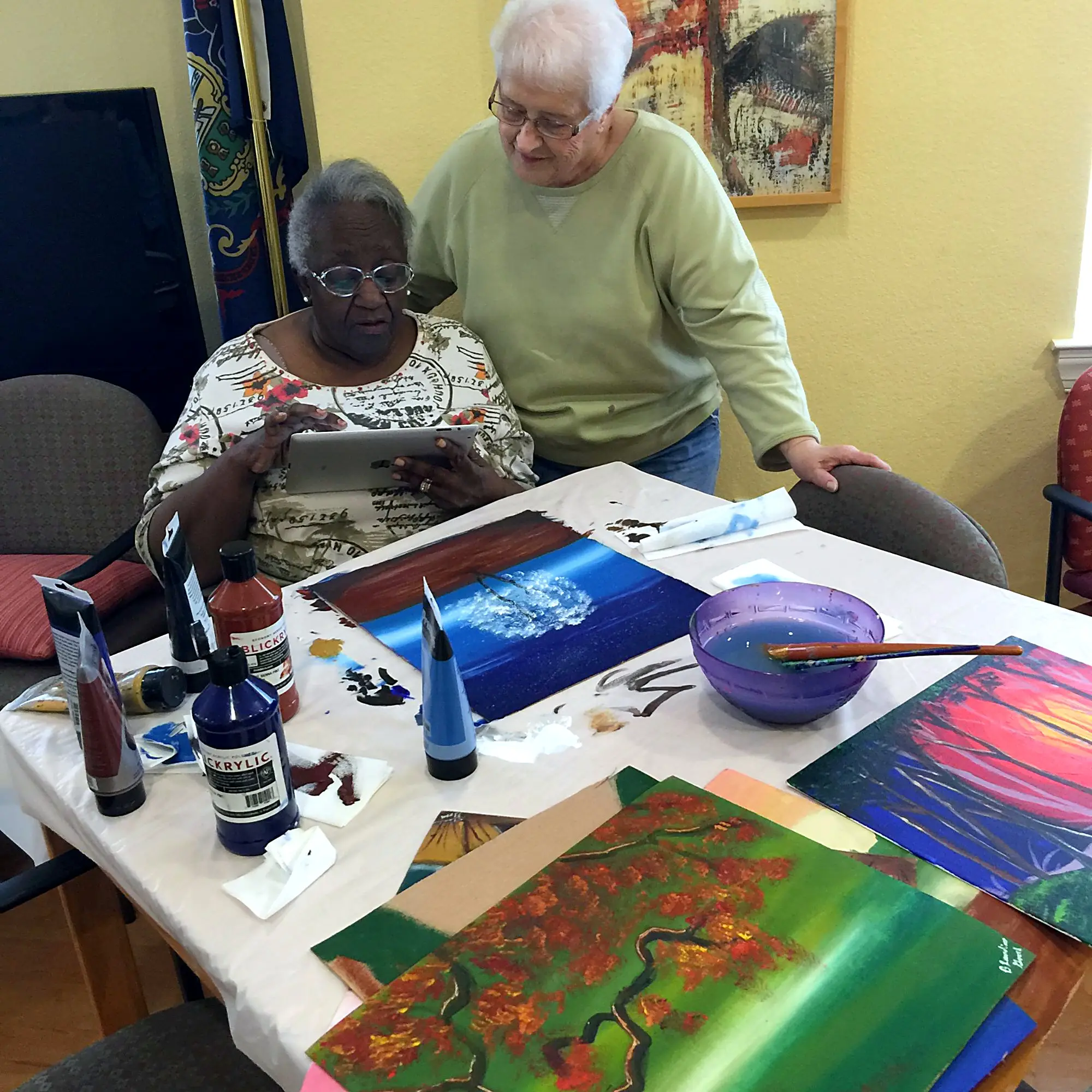 Two seniors choosing a reference photo on a tablet